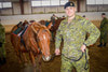 Cpl Hall standing and looking proud after receiving his spurs Senator tacked up with one of the new steel arch saddles