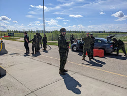 LdSH(RC) soldiers watch carefully as a car is searched for weapons and contraband and its occupant is detained.